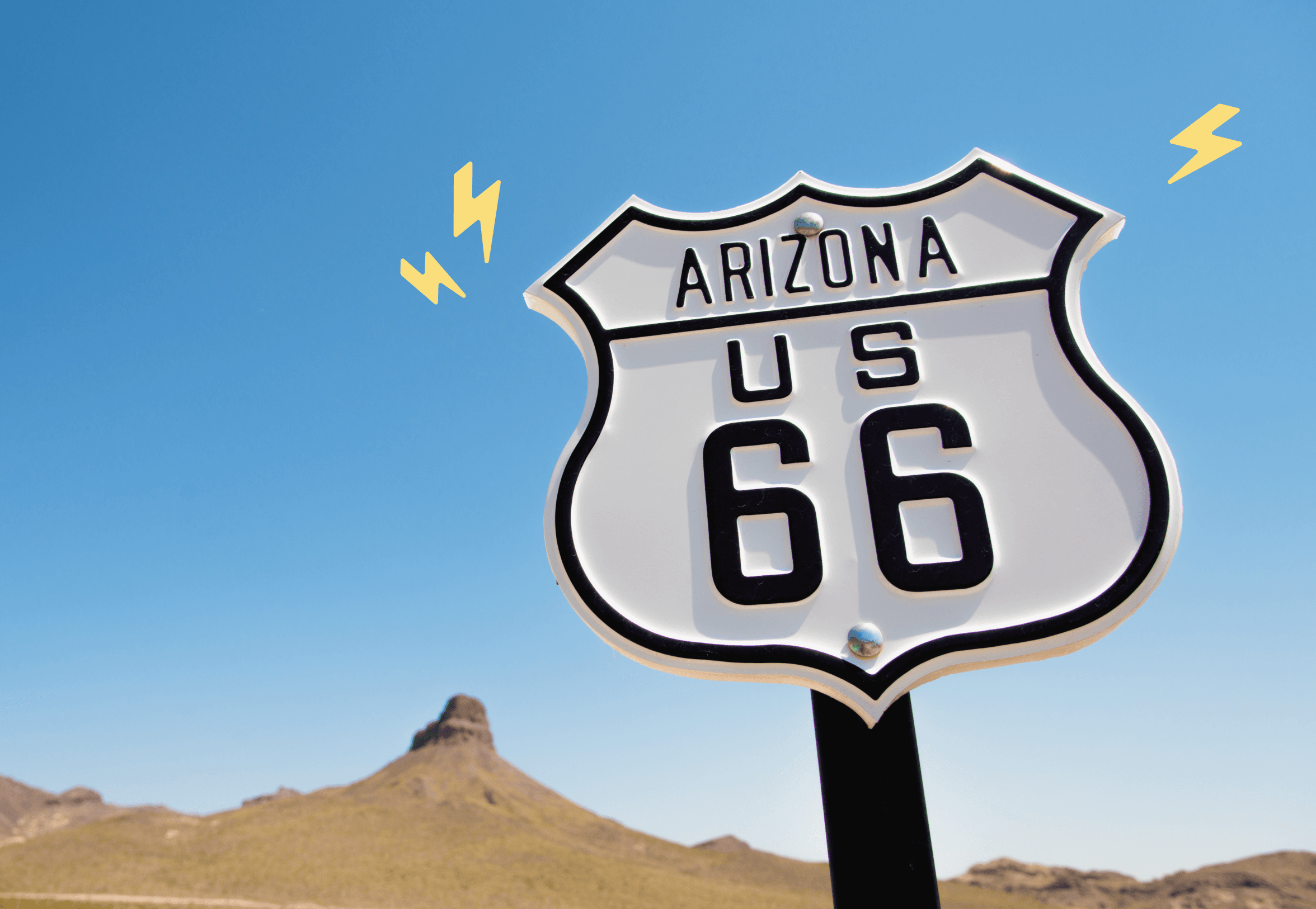 White Arizona US route 66 sign in front of a clear blue sky with rock formations in the background. There are 3 yellow illustrated lightning bolt icons framing the sign.