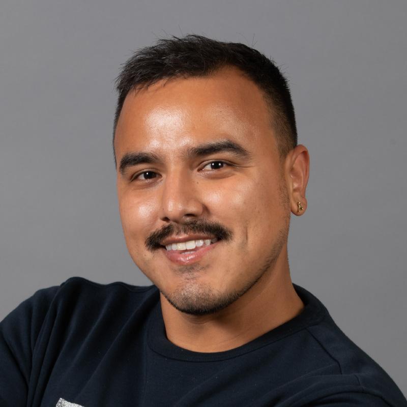 Headshot of Esteban Yepez, who is slightly smiling and has short dark black hair and a mustache. He is wearing a dark navy sweater.