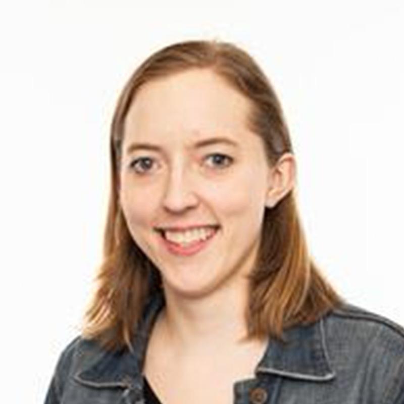 Headshot of Natalie Weires, who is smiling and has shoulder length reddish brown hair. She wears a denim jacket.